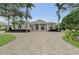 Elegant home with a circular driveway, columns, and lush landscaping, creating a grand and inviting curb appeal at 3360 Founders Club Dr, Sarasota, FL 34240