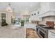 Spacious white kitchen featuring stone floors, large island, stainless steel appliances, and backyard view at 3360 Founders Club Dr, Sarasota, FL 34240