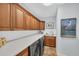 Bright laundry room featuring wood cabinets and modern appliances at 3360 Founders Club Dr, Sarasota, FL 34240