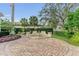 Circular fountain with lush landscaping and brick pavers at 3360 Founders Club Dr, Sarasota, FL 34240