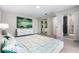 Modern bedroom with ensuite bathroom access, large bed, and light wood floors at 3520 Wilderness W Blvd, Parrish, FL 34219