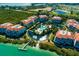 Aerial view of condo community featuring lush landscaping, a central pool area, and waterfront access at 380 Gulf Of Mexico Dr # 536, Longboat Key, FL 34228