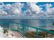 Balcony view of turquoise-blue water and white clouds from glass railing and outdoor seating at 380 Gulf Of Mexico Dr # 536, Longboat Key, FL 34228