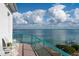 Balcony view showcasing turquoise water, pier, and expansive sky from outdoor seating at 380 Gulf Of Mexico Dr # 536, Longboat Key, FL 34228