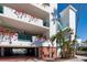 Bright white condo building featuring lovely bougainvillea vines, turquoise railings, and covered parking at 380 Gulf Of Mexico Dr # 536, Longboat Key, FL 34228