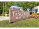 Community sign for 'Tangerine Bay Club' surrounded by manicured greenery and flowers at 380 Gulf Of Mexico Dr # 536, Longboat Key, FL 34228