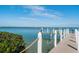 Wooden dock featuring white pilings, rope accents and bench overlooking the water at 380 Gulf Of Mexico Dr # 536, Longboat Key, FL 34228