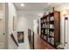 Bright hallway with hardwood floors and a large wooden bookshelf stocked with books and decor at 380 Gulf Of Mexico Dr # 536, Longboat Key, FL 34228