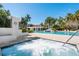 Community pool, spa and waterfall feature, lined with mature palms and manicured landscaping at 380 Gulf Of Mexico Dr # 536, Longboat Key, FL 34228