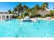 Large community pool featuring waterfalls and ample lounge seating surrounded by palm trees at 380 Gulf Of Mexico Dr # 536, Longboat Key, FL 34228