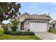 Tan house with a white garage door and large magnolia tree at 4104 Reflections Pkwy, Sarasota, FL 34233