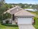 Single-story house with a two-car garage, landscaped lawn, and lake view at 4104 Reflections Pkwy, Sarasota, FL 34233