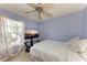 Relaxing bedroom featuring a ceiling fan, tiled floors, and a sunlit window with curtains at 4410 70Th E Dr, Sarasota, FL 34243