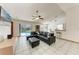 Spacious living room featuring tiled flooring, a ceiling fan, and sliding glass doors leading to the pool area at 4410 70Th E Dr, Sarasota, FL 34243