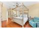 Bright bedroom featuring a large four-poster bed and hardwood floors at 4941 Bridgehampton Blvd, Sarasota, FL 34238