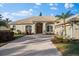 Single-story home with tile roof, two-car garage, and landscaped yard at 4941 Bridgehampton Blvd, Sarasota, FL 34238