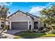 Single-story home with gray garage door and landscaping at 5255 Cicerone St, Sarasota, FL 34238