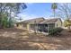 Home's back features a screened porch and large yard at 5504 Birchwood Rd, Spring Hill, FL 34608