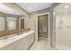 Bathroom with double sinks, shower and textured walls at 6009 Bonaventure Pl, Sarasota, FL 34243