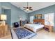 Spacious bedroom with hardwood floors, blue walls, and a ceiling fan at 6442 Mourning Dove Dr # 6442, Bradenton, FL 34210