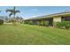 Landscaped backyard with grassy lawn and screened patio at 7157 Fairway Bend Cir, Sarasota, FL 34243