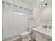 Clean bathroom with white toilet and sink, shower, and white curtain at 7157 Fairway Bend Cir, Sarasota, FL 34243