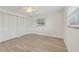 Simple bedroom with grey vinyl flooring and white closet doors at 7157 Fairway Bend Cir, Sarasota, FL 34243