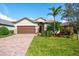 Attractive one-story home with brown garage door, landscaping, and paver driveway at 7409 Chester Trl, Bradenton, FL 34202