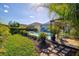 Lush backyard with stepping stones leading to a gazebo overlooking the pool and spa area at 7453 Featherstone Blvd, Sarasota, FL 34238