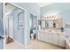 Bright bathroom featuring double sinks, a decorative mirror, and soft blue walls at 7453 Featherstone Blvd, Sarasota, FL 34238