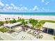 Bustling beach view with sugar-white sand, turquoise water, and swaying palm trees under a sunny sky at 7453 Featherstone Blvd, Sarasota, FL 34238