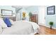 Light-filled bedroom with light blue walls, wood floors, and rustic wood dresser and mirror at 7453 Featherstone Blvd, Sarasota, FL 34238