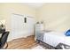 Bedroom featuring light yellow walls, hardwood floors, and two double-door closets at 7453 Featherstone Blvd, Sarasota, FL 34238