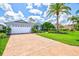 View of the home's exterior with brick-paved driveway and well-maintained landscaping at 7453 Featherstone Blvd, Sarasota, FL 34238