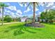 Home exterior featuring manicured lawn and tropical landscaping with palm trees at 7453 Featherstone Blvd, Sarasota, FL 34238