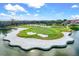 Scenic golf course with a sand trap in a lake under a blue sky with some clouds on a sunny day at 7453 Featherstone Blvd, Sarasota, FL 34238