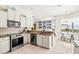 Open-concept kitchen with stainless steel appliances, granite countertops, and breakfast bar overlooking dining area at 7453 Featherstone Blvd, Sarasota, FL 34238