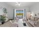 Bright living room with neutral decor, slider doors to the patio, and ceiling fan at 7453 Featherstone Blvd, Sarasota, FL 34238