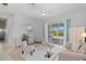 Bright living room with slider doors to the patio, light colored furnishings and decor at 7453 Featherstone Blvd, Sarasota, FL 34238