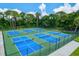 Aerial view of new pickleball courts ready for a match surrounded by a high fence and trees at 7453 Featherstone Blvd, Sarasota, FL 34238