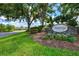 Stonebridge community sign on a manicured green lawn against a backdrop of mature trees and a blue, partly cloudy sky at 7453 Featherstone Blvd, Sarasota, FL 34238