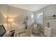 A well-lit home office with a desk, chair, and window with plantation shutters at 7590 Summerland Cv, Bradenton, FL 34202