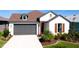 White farmhouse exterior with brown roof, landscaping, and a two-car garage at 8219 Abalone Loop, Parrish, FL 34219