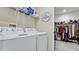 Bright laundry room features washer, dryer, shelving, and walk-in closet at 8219 Abalone Loop, Parrish, FL 34219