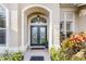 Elegant entryway with double doors, arched entry, and lush landscaping at 8624 Woodbriar Dr, Sarasota, FL 34238