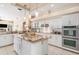 Island kitchen with white cabinets, granite countertops, and stainless steel appliances at 8624 Woodbriar Dr, Sarasota, FL 34238