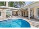 Stunning freeform pool with paved patio and access to interior at 8624 Woodbriar Dr, Sarasota, FL 34238