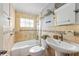 Tiled bathroom featuring a shower-tub combo, vanity sink, and window for natural light at 866 N Shore Dr, Anna Maria, FL 34216