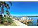 Boat dock view along the water with lush tropical landscaping under clear, blue skies at 9397 Midnight Pass Rd # 603, Sarasota, FL 34242