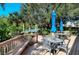 Outdoor patio featuring tables with umbrellas, chairs and lush greenery at 9397 Midnight Pass Rd # 603, Sarasota, FL 34242